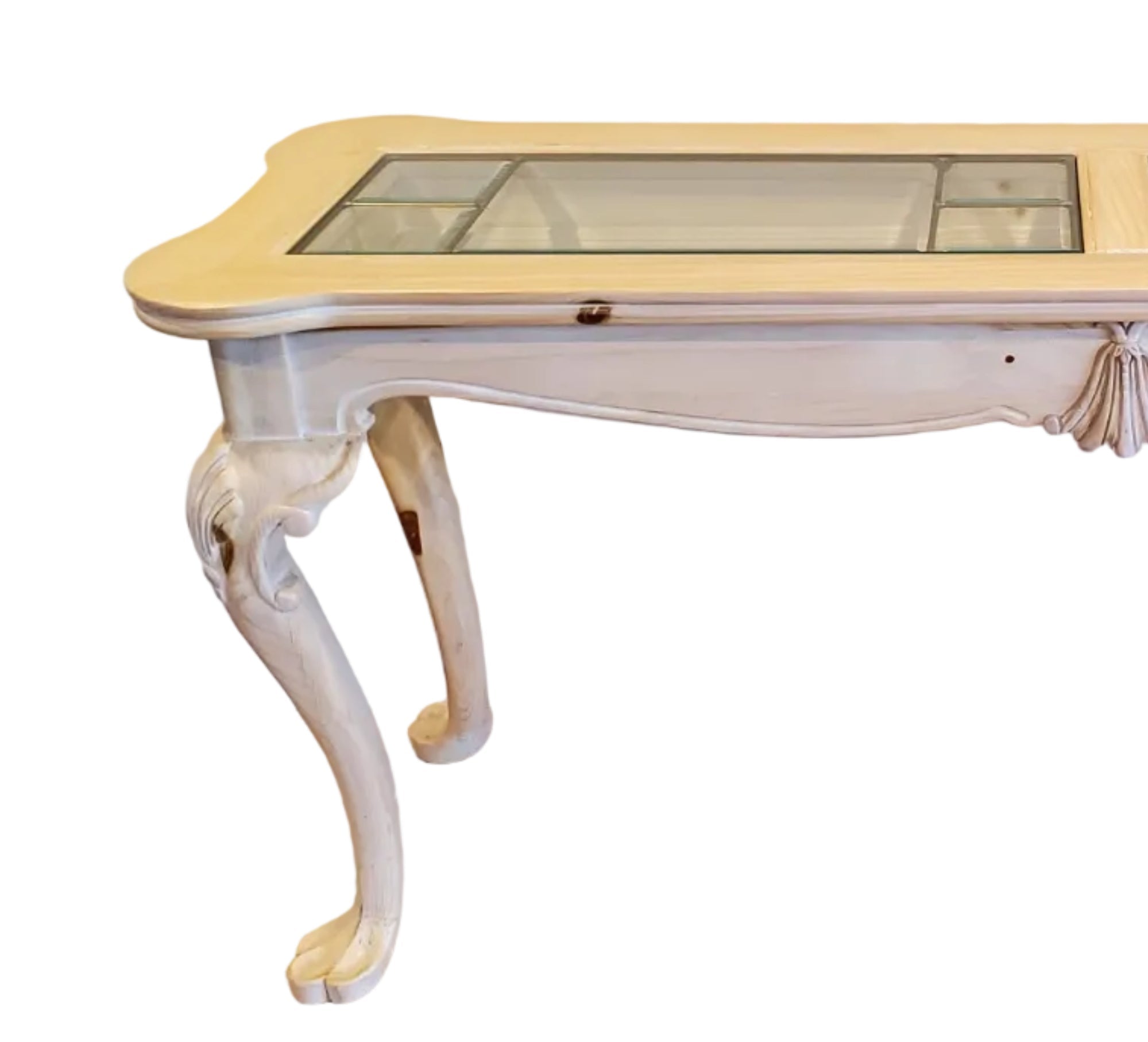 A vintage console table with a light wooden finish and glass panels on top, featuring decorative legs and a smooth surface, against a neutral wall.