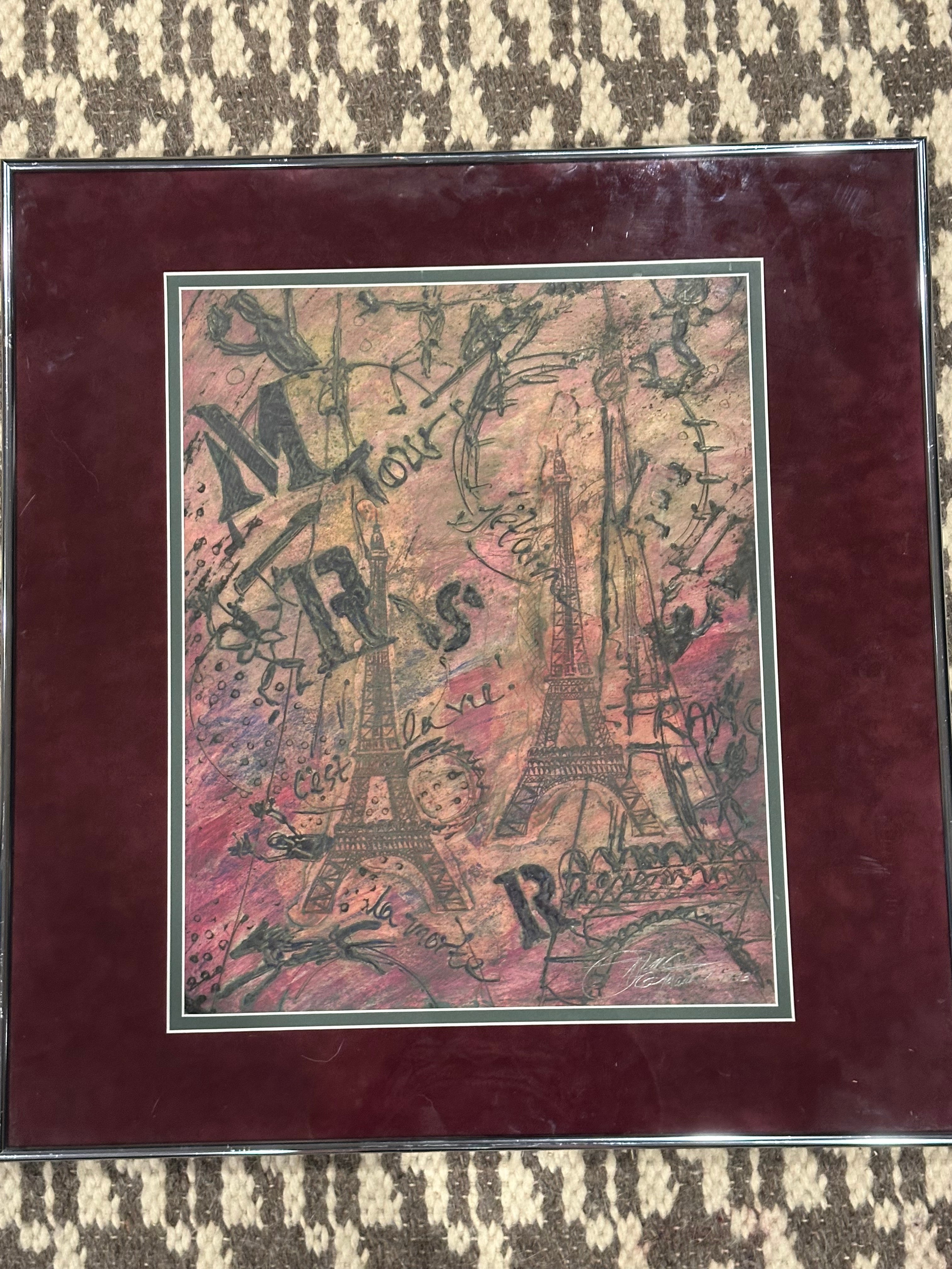 A framed artwork featuring intertwined Eiffel Towers with artistic text and sketches, set against a colorful background of pink and brown tones.