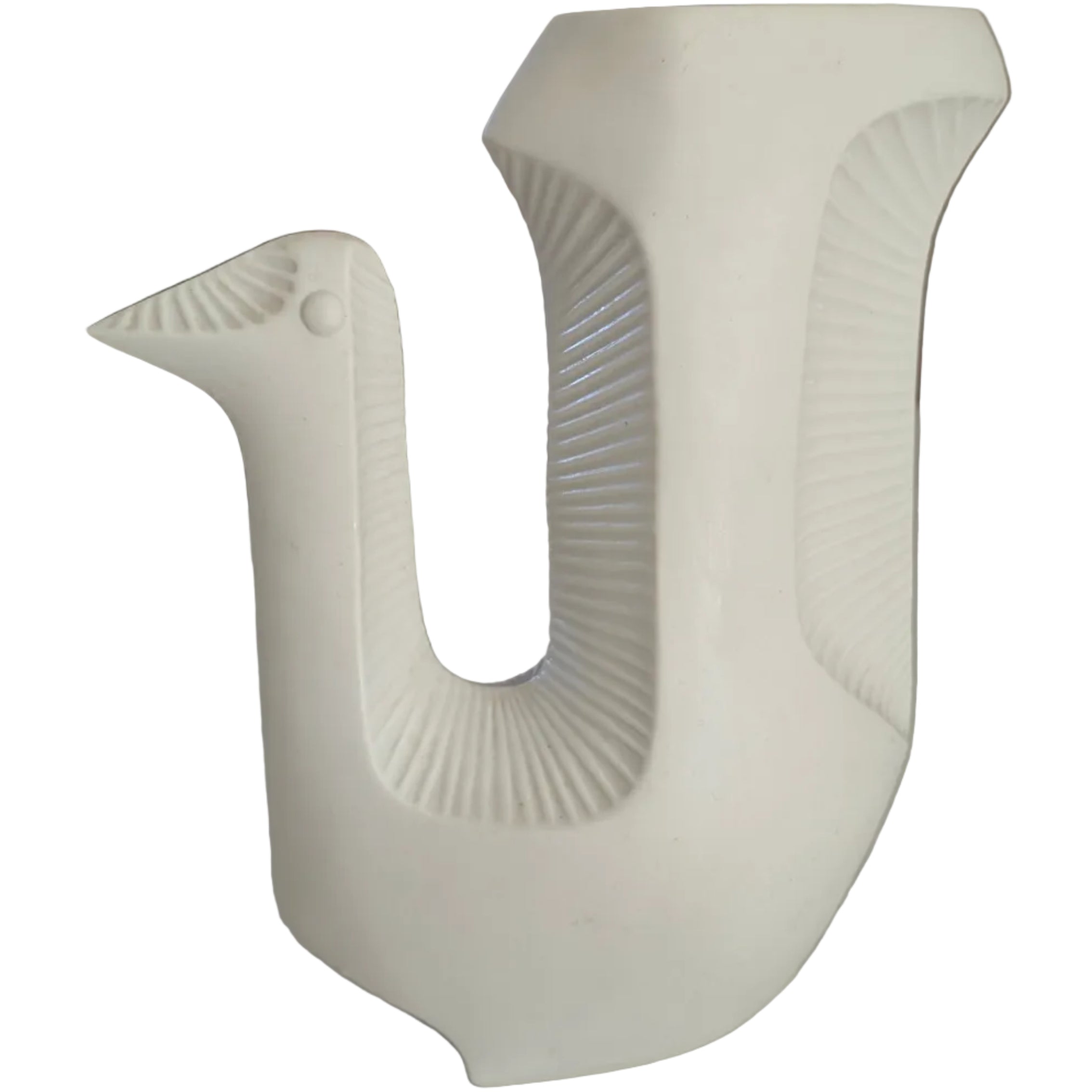 A white ceramic vase shaped like a bird, featuring a textured body and a distinctive beak, placed on a light-colored surface with a blurred background.