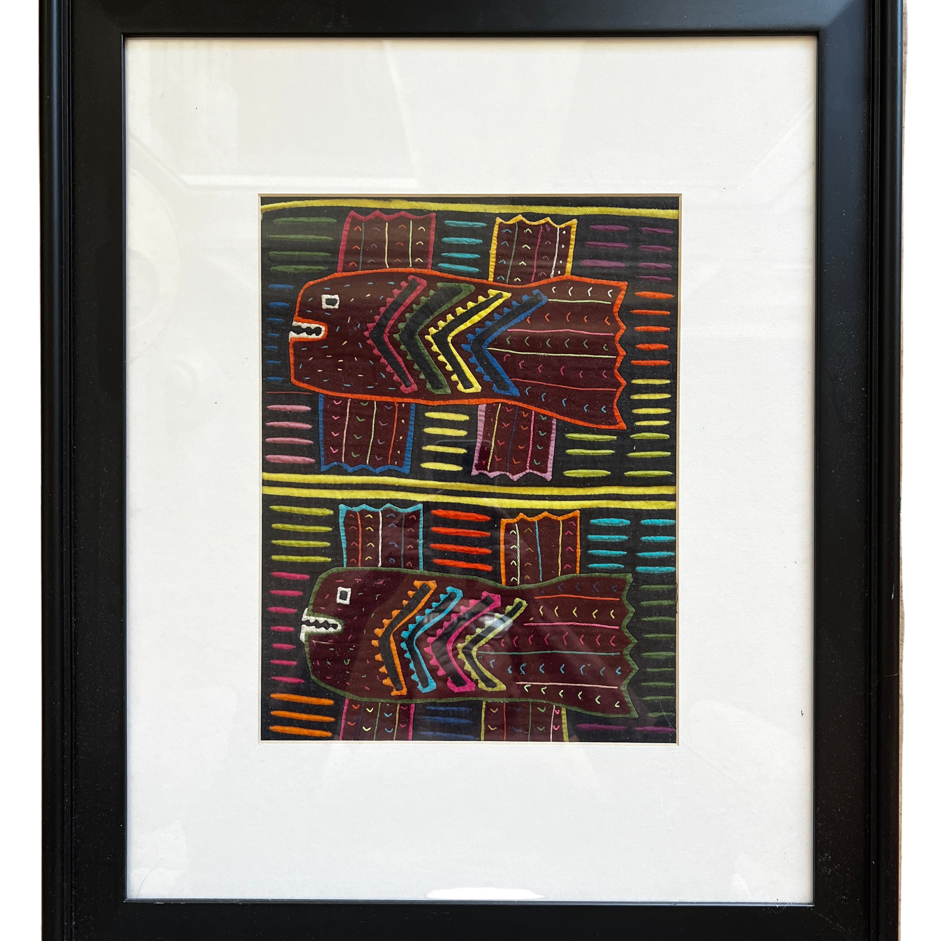 A framed artwork features two stylized fish against a colorful striped background, using vibrant colors and geometric patterns.