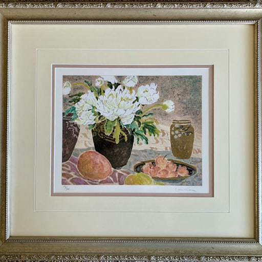 Framed artwork featuring white flowers in a vase, surrounded by fruit, including peaches and an olive jar, on a patterned cloth background.