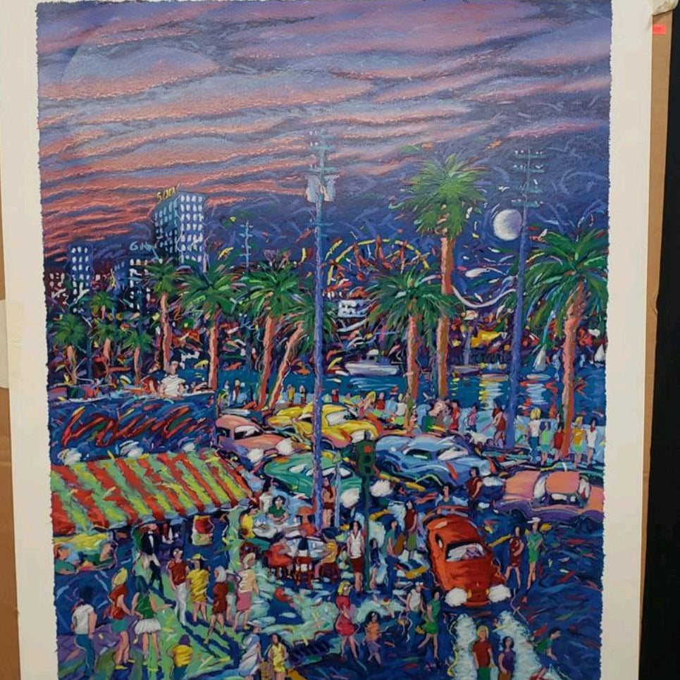 "Down by the Boardwalk" by James Talmadge, an Artist's Proof. The vibrant painting depicts a bustling boardwalk scene at sunset, with palm trees, colorful cars, and crowds of people enjoying the evening. The sky features swirling hues of pink, purple, and blue, with city buildings and a Ferris wheel in the background.
