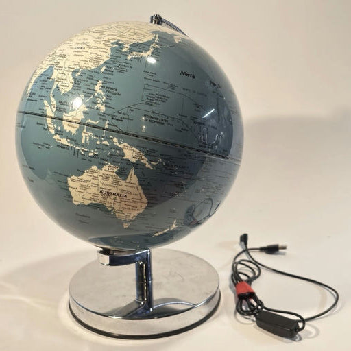 A blue globe features outlined continents and countries, resting on a chrome base. A USB cable is connected to the globe's side.