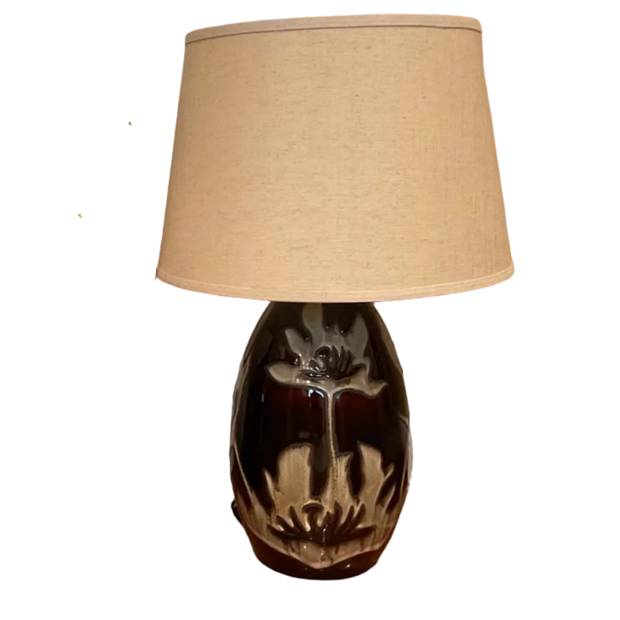 Two matching table lamps with beige lampshades sit on a polished wooden floor, positioned in front of a white door and framed art.