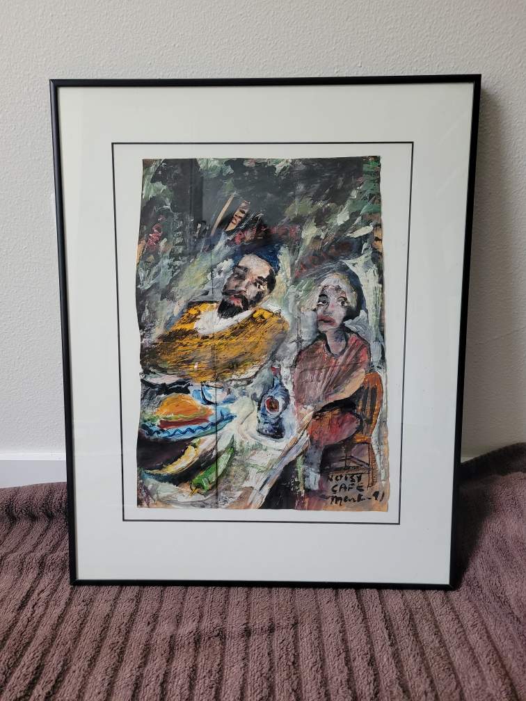 Framed artwork featuring two figures, one male and one female, seated at a table with food and a drink. Vibrant colors and expressive brushstrokes.