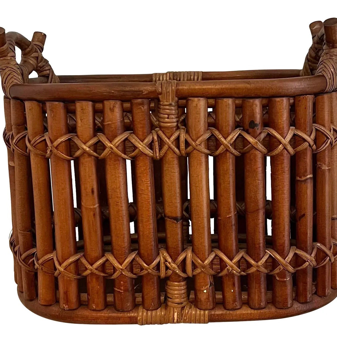 A woven bamboo basket featuring a rounded shape, intricate cross-pattern design, and sturdy handles for easy carrying and storage.