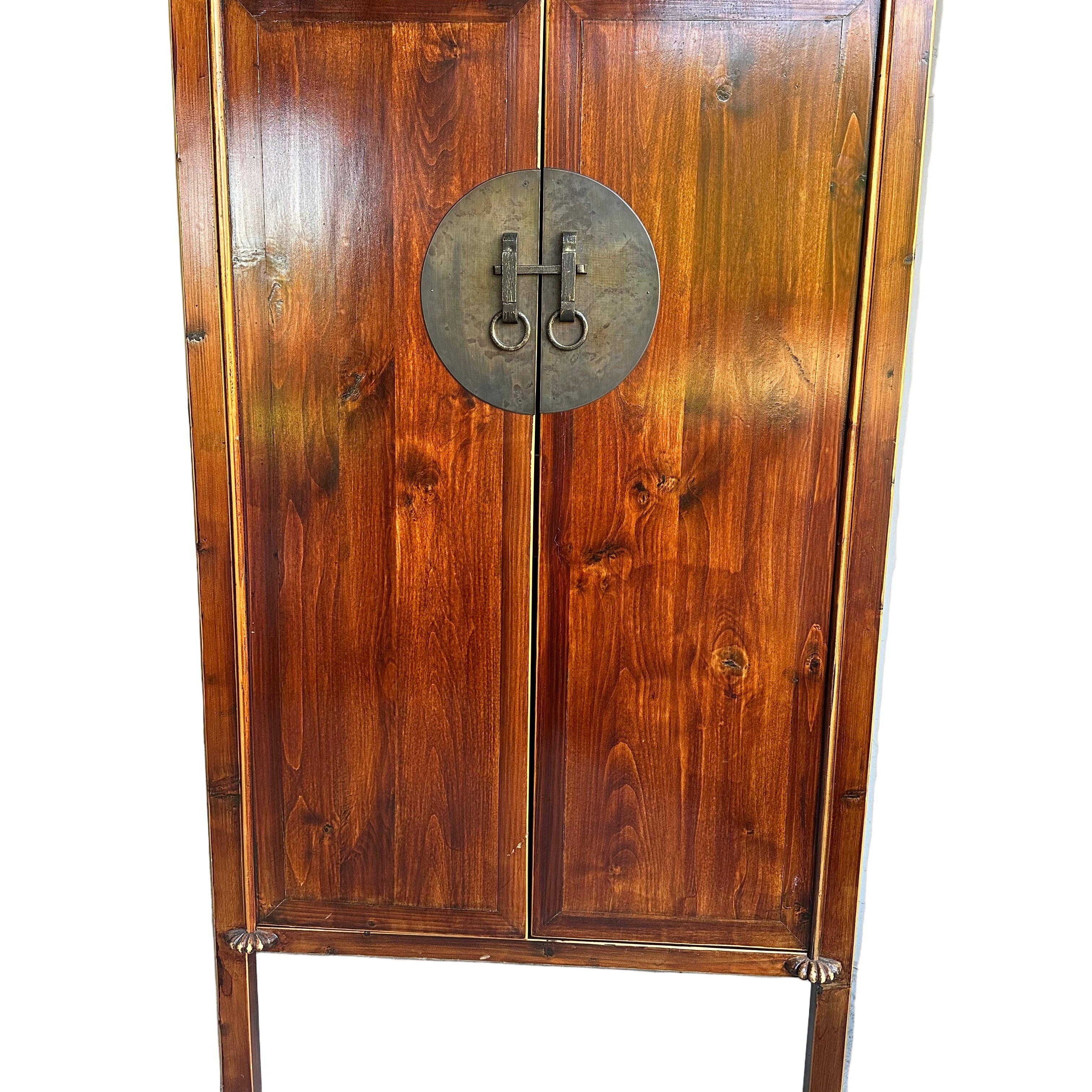 A wooden cabinet with a rich, polished finish and circular metal handles, featuring two doors and decorative legs, stands against a neutral background.