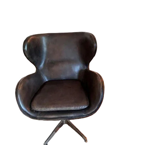 A stylish, modern black leather chair with a distinctive rounded backrest and a swivel base, set on a wooden floor with a light carpet.