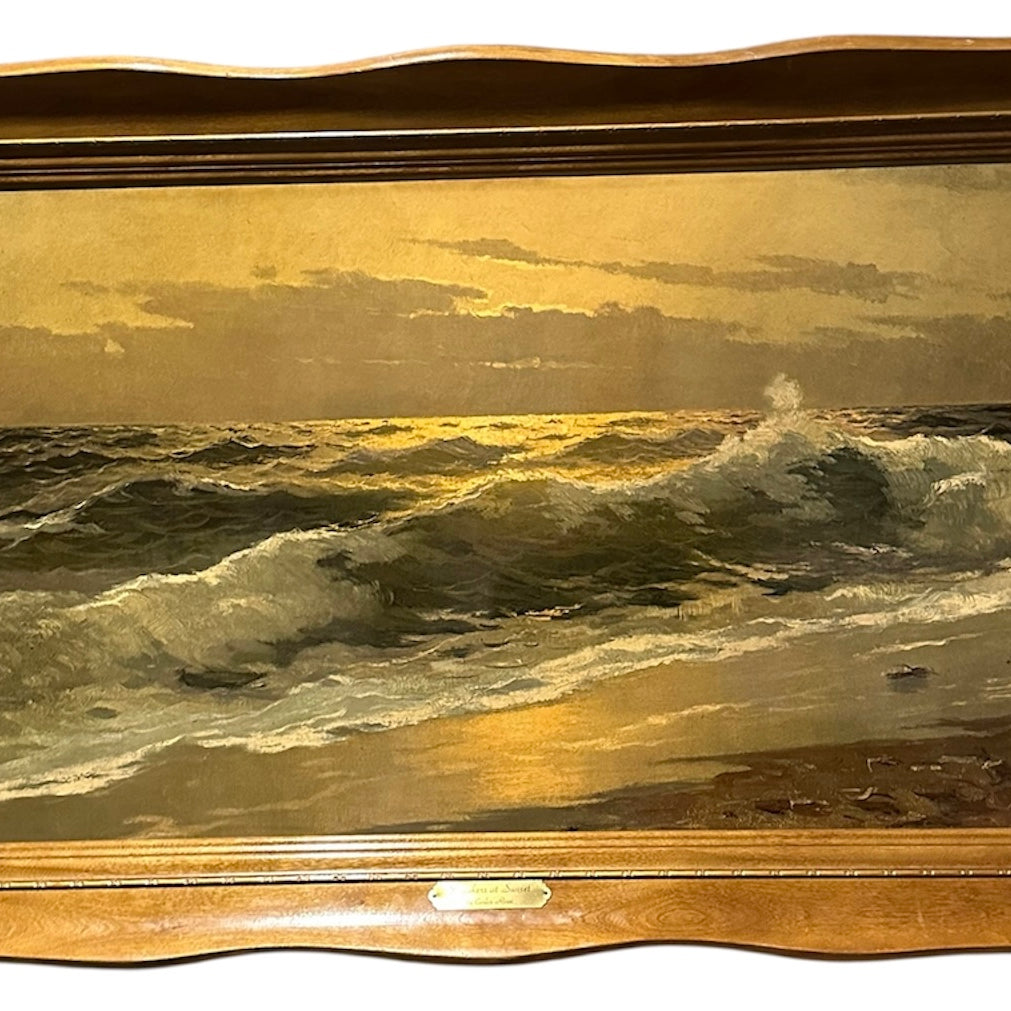 A seascape painting depicts waves crashing on a shore during sunset, with light reflecting off the water, framed in a wavy wooden frame.