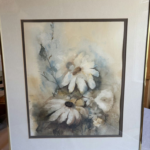 A framed watercolor painting of white daisies with soft blue and beige hues, featuring delicate brush strokes and a serene background.