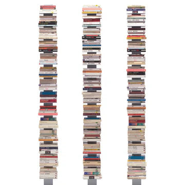 Three tall book stacks are arranged on sleek bases, each filled with a variety of colorful book covers and spines, creating a visually striking display.