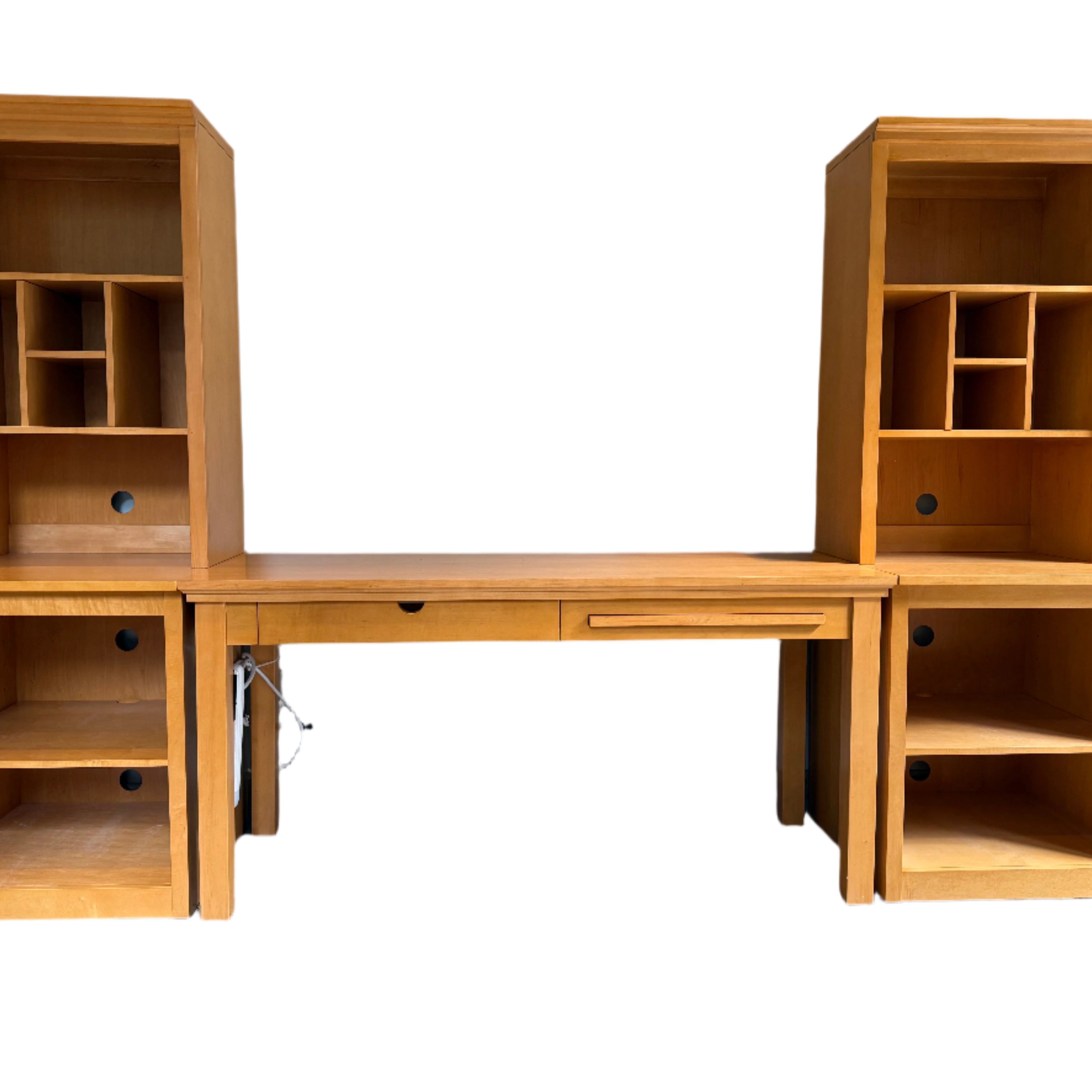 A wooden desk with two tall bookcases on each side. The desk features a pull-out drawer, and the bookcases have cubbies and open shelves.