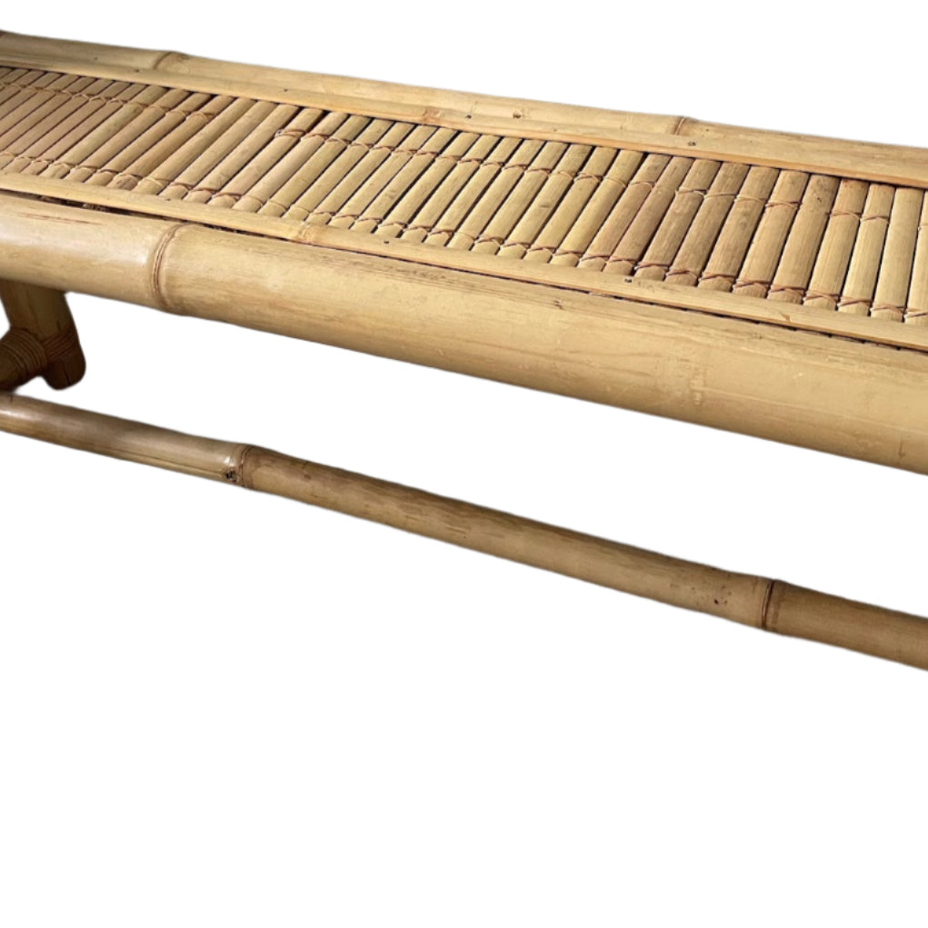 A simple bamboo bench with a slatted top, placed against a green wall. It features rounded corners and sturdy legs on a carpeted floor.