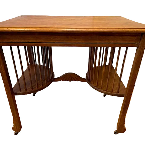 A vintage wooden table with a smooth surface and two curved shelves below, featuring vertical slats on the sides and resting on four rolled legs.