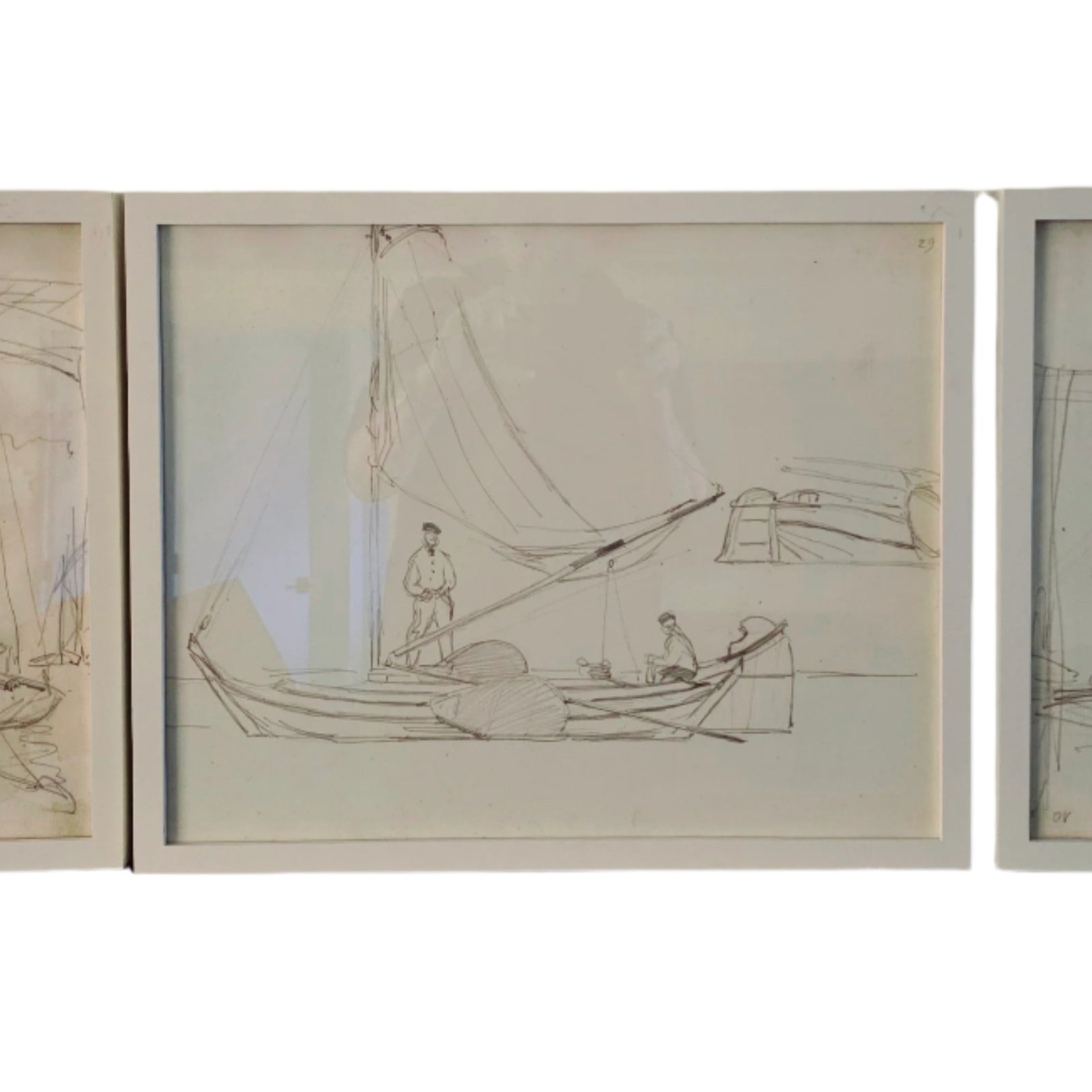 Three framed sketches of boats and figures, showcasing simple lines and a nautical theme, displayed against a neutral wall.