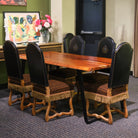 Dining area with wooden table and chairs against a green wall.