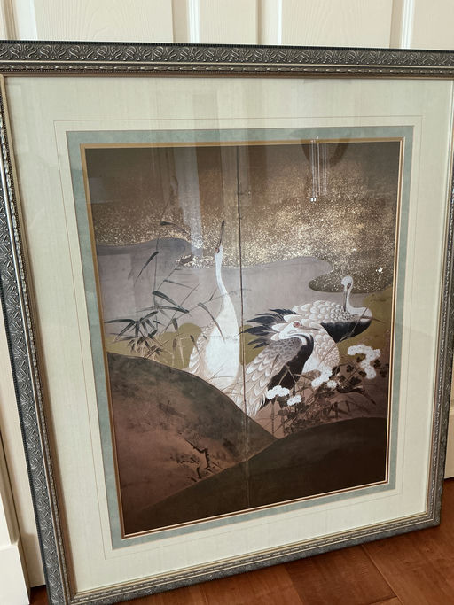 A framed artwork depicting elegant cranes amidst stylized vegetation and shimmering backgrounds, showcasing intricate details and muted colors.