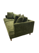 Green upholstered chair in a store setting with shelves and products in the background