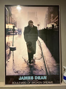 A framed painting of James Dean walking alone in the rain, titled "Boulevard of Broken Dreams," with a somber urban background.