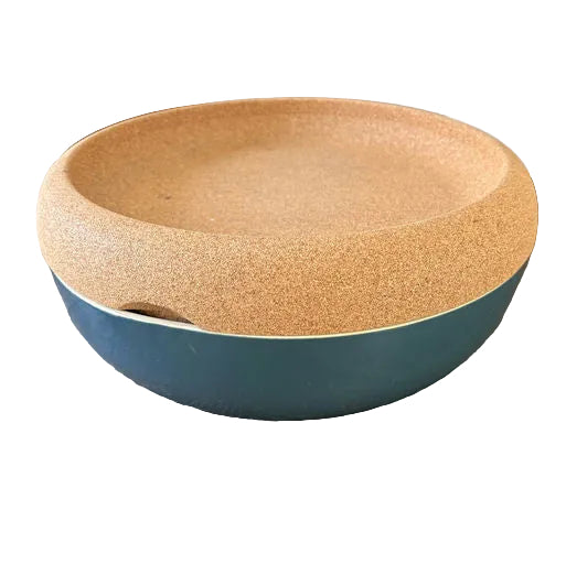 A round bowl with a textured cork lid, resting on a wooden table. The bowl features a blue exterior and a natural cork finish on top.