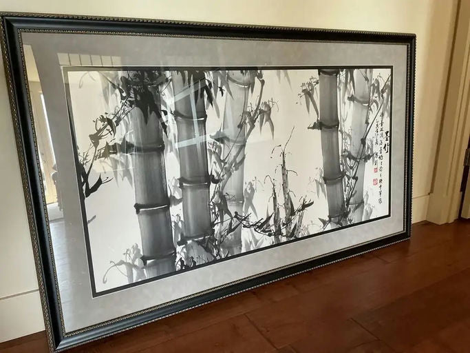 A black-and-white ink painting of bamboo, framed elegantly, showcasing delicate brushwork and traditional Chinese calligraphy on the side.
