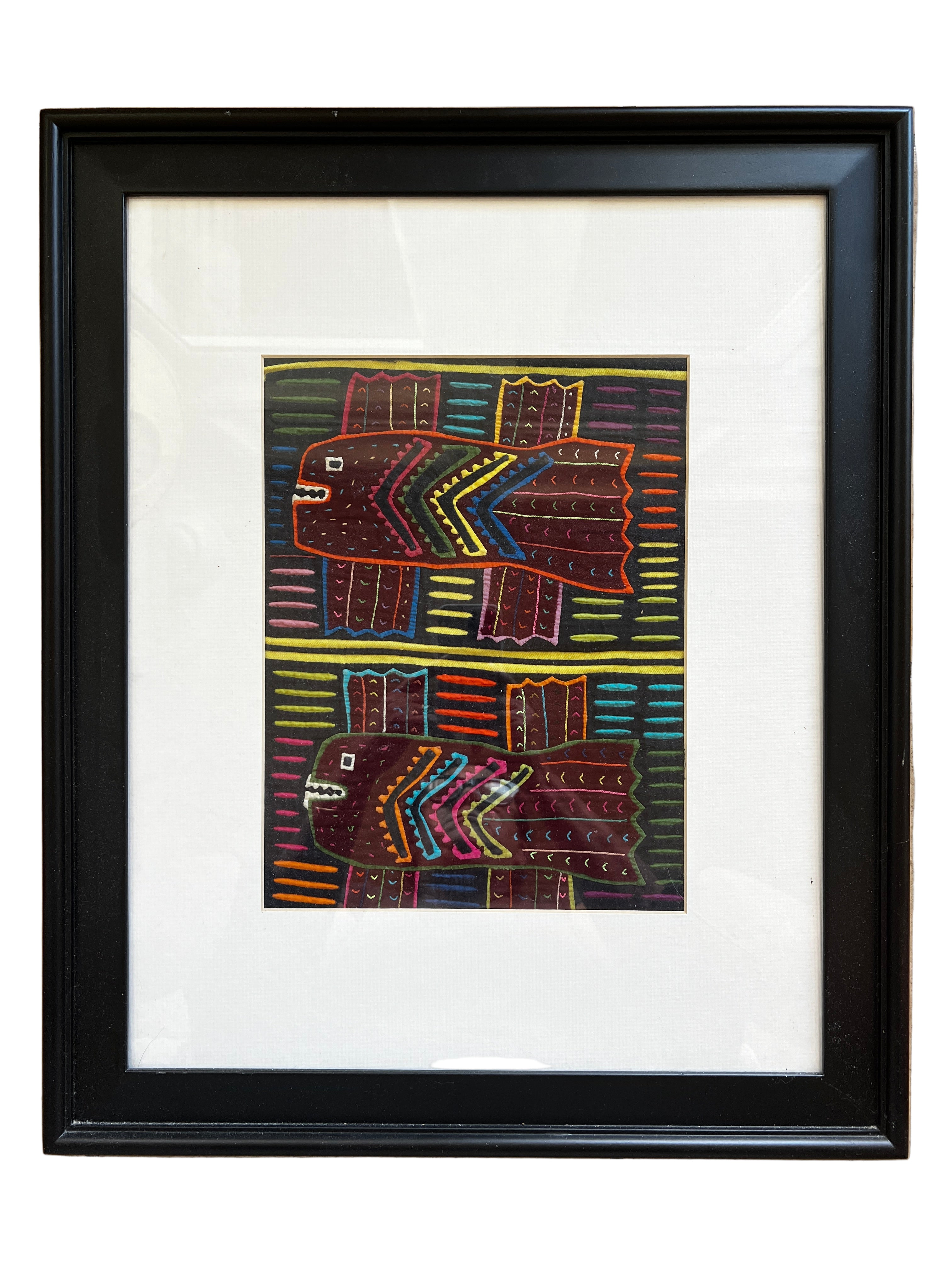 A framed artwork features two stylized fish against a colorful striped background, using vibrant colors and geometric patterns.