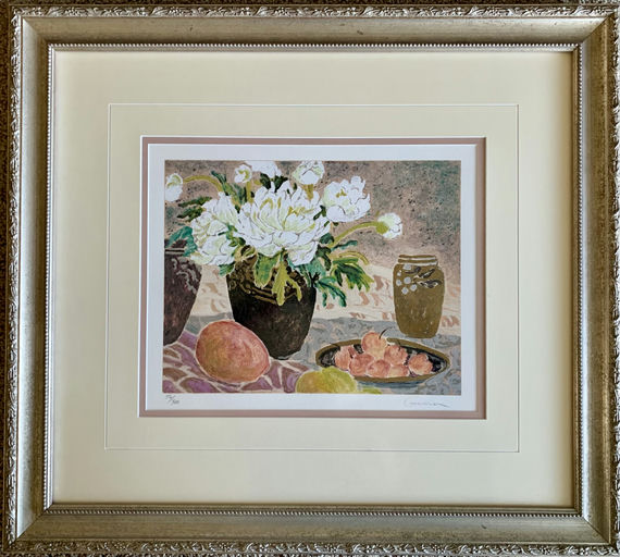 Framed artwork featuring white flowers in a vase, surrounded by fruit, including peaches and an olive jar, on a patterned cloth background.