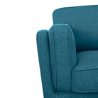 A detailed view of the blue sofa's armrest, highlighting the upholstery texture and the soft padding of the armrest.