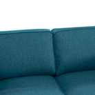 A detailed view of the upper part of the blue sofa, focusing on the two back cushions and the stitching detail of the upholstery.