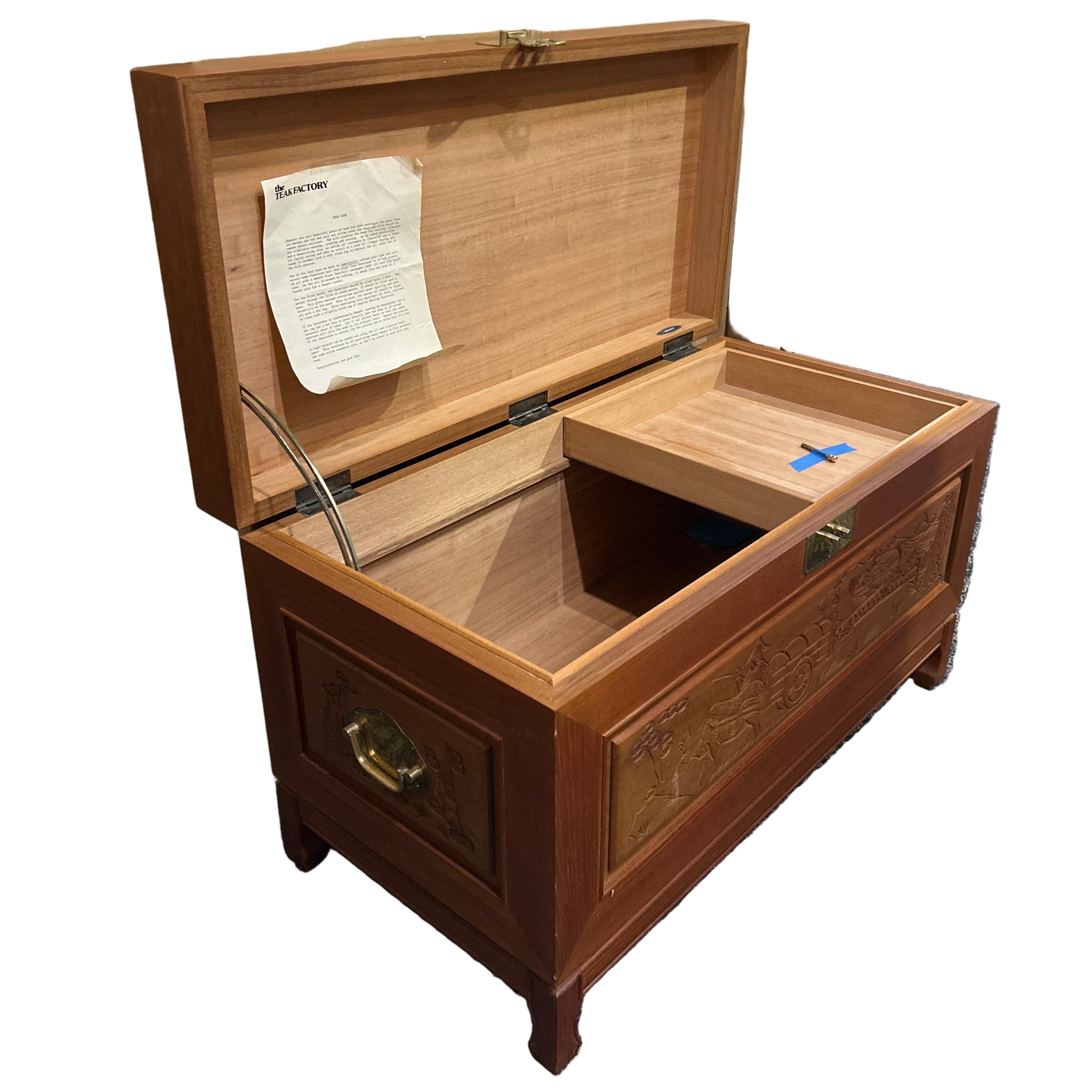 Wooden jewelry box with a document inside on a blue carpeted floor.