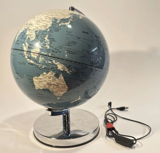A blue globe features outlined continents and countries, resting on a chrome base. A USB cable is connected to the globe's side.