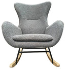 A modern gray rocking chair with a textured fabric cushion and wooden rockers, set against a workshop background with scattered boxes and materials.