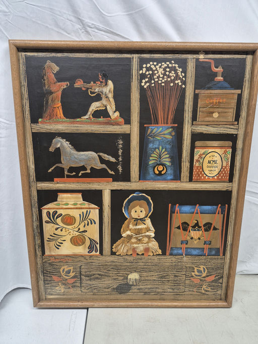 A framed artwork featuring a rustic display of various items: a bear, a horse, flowers, a coffee grinder, jars, and a doll adorned with a bonnet.