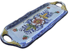 A decorative blue and white serving tray with floral designs and handles rests on a wooden table, showcasing intricate craftsmanship and color.