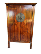 A wooden cabinet with a rich, polished finish and circular metal handles, featuring two doors and decorative legs, stands against a neutral background.