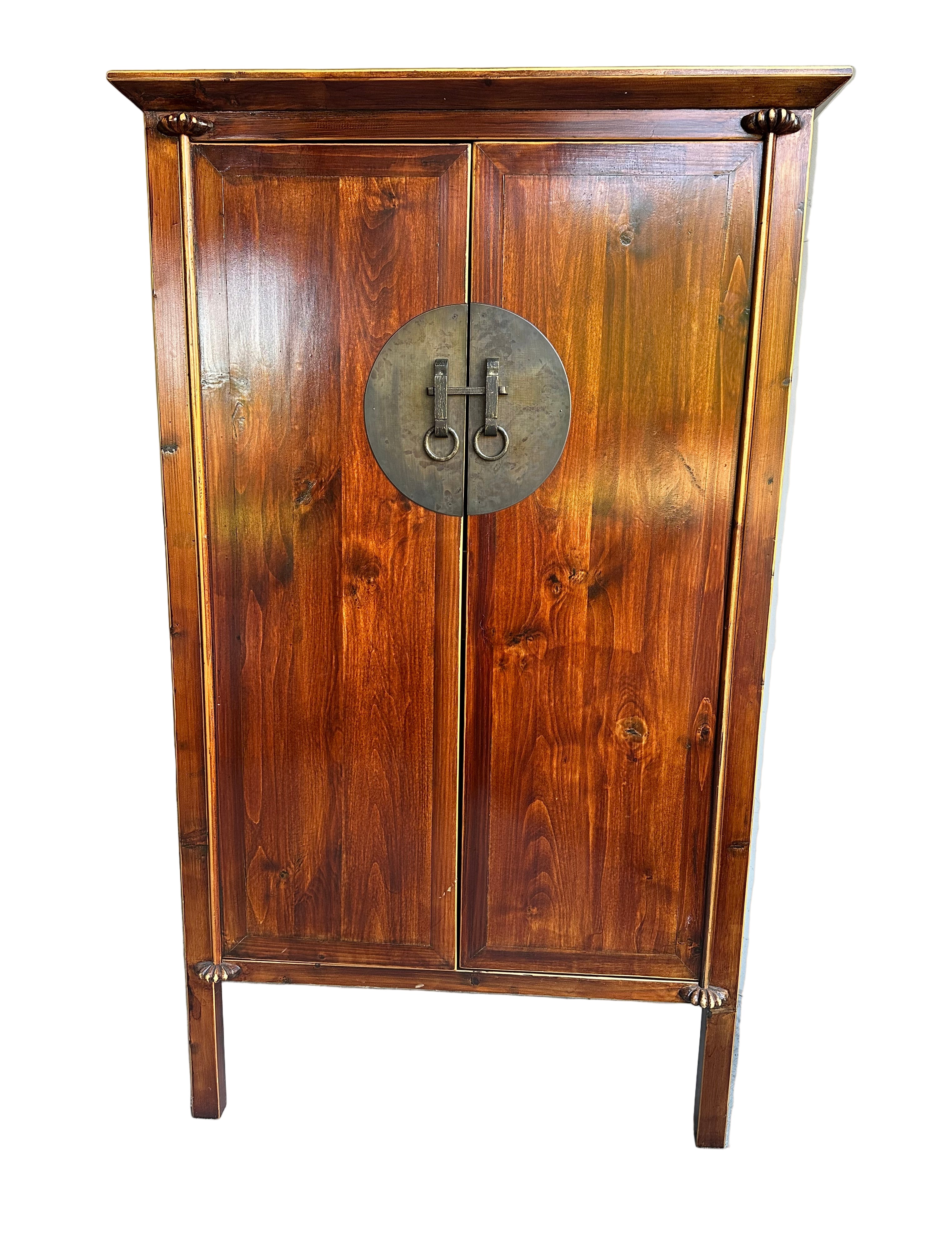 A wooden cabinet with a rich, polished finish and circular metal handles, featuring two doors and decorative legs, stands against a neutral background.