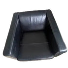 A modern black leather armchair viewed from above, featuring clean lines and a minimalist design, set on a light wooden floor.