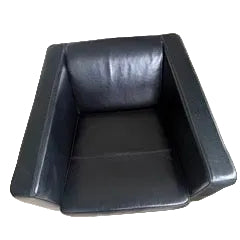 A modern black leather armchair viewed from above, featuring clean lines and a minimalist design, set on a light wooden floor.