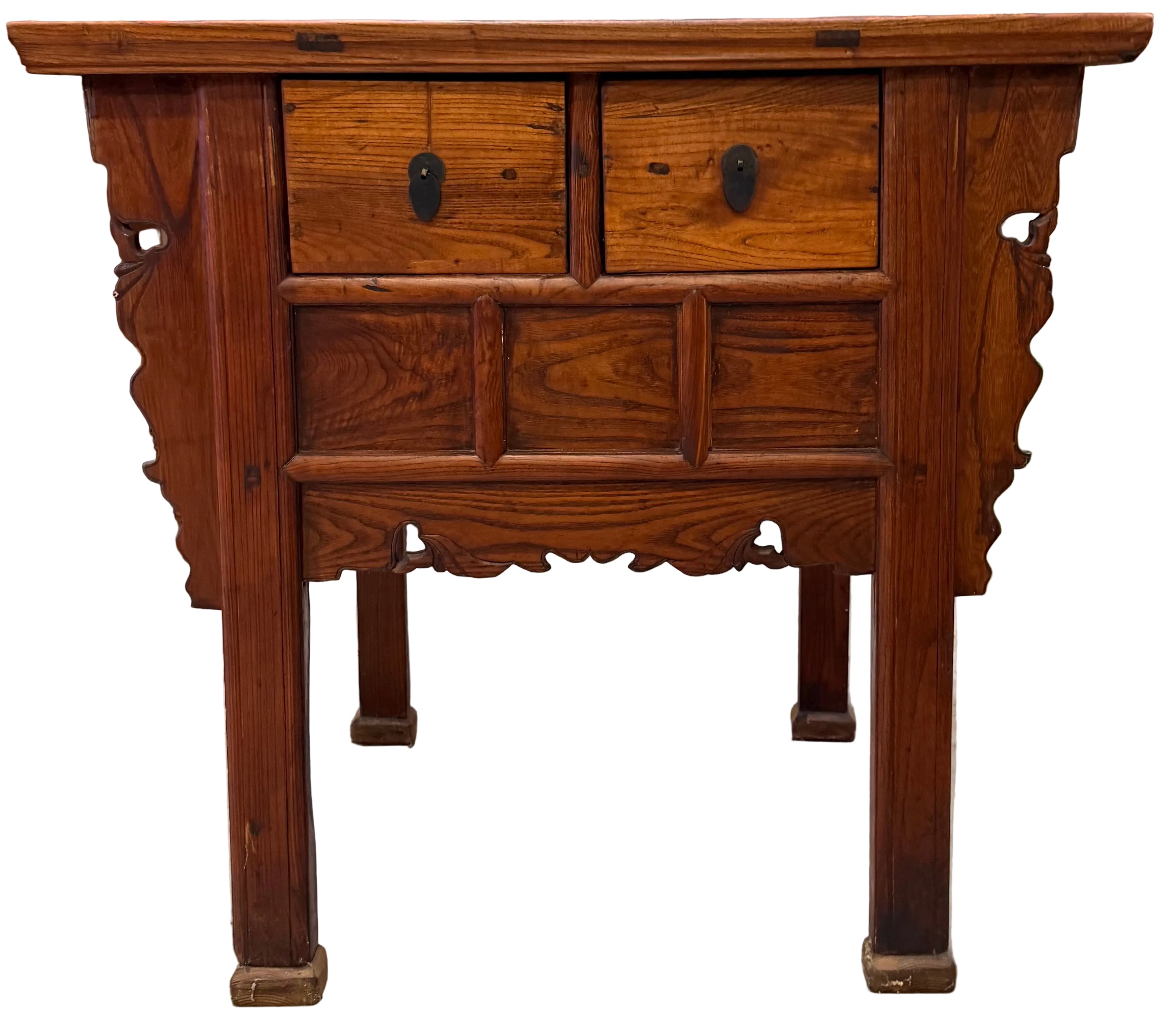 A wooden side table featuring two drawers, intricate carvings on the sides, and a polished finish, set against a cluttered background.
