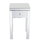 A mirrored side table with a single drawer and a crystal knob. The shiny surface reflects light, adding elegance to any room decor.