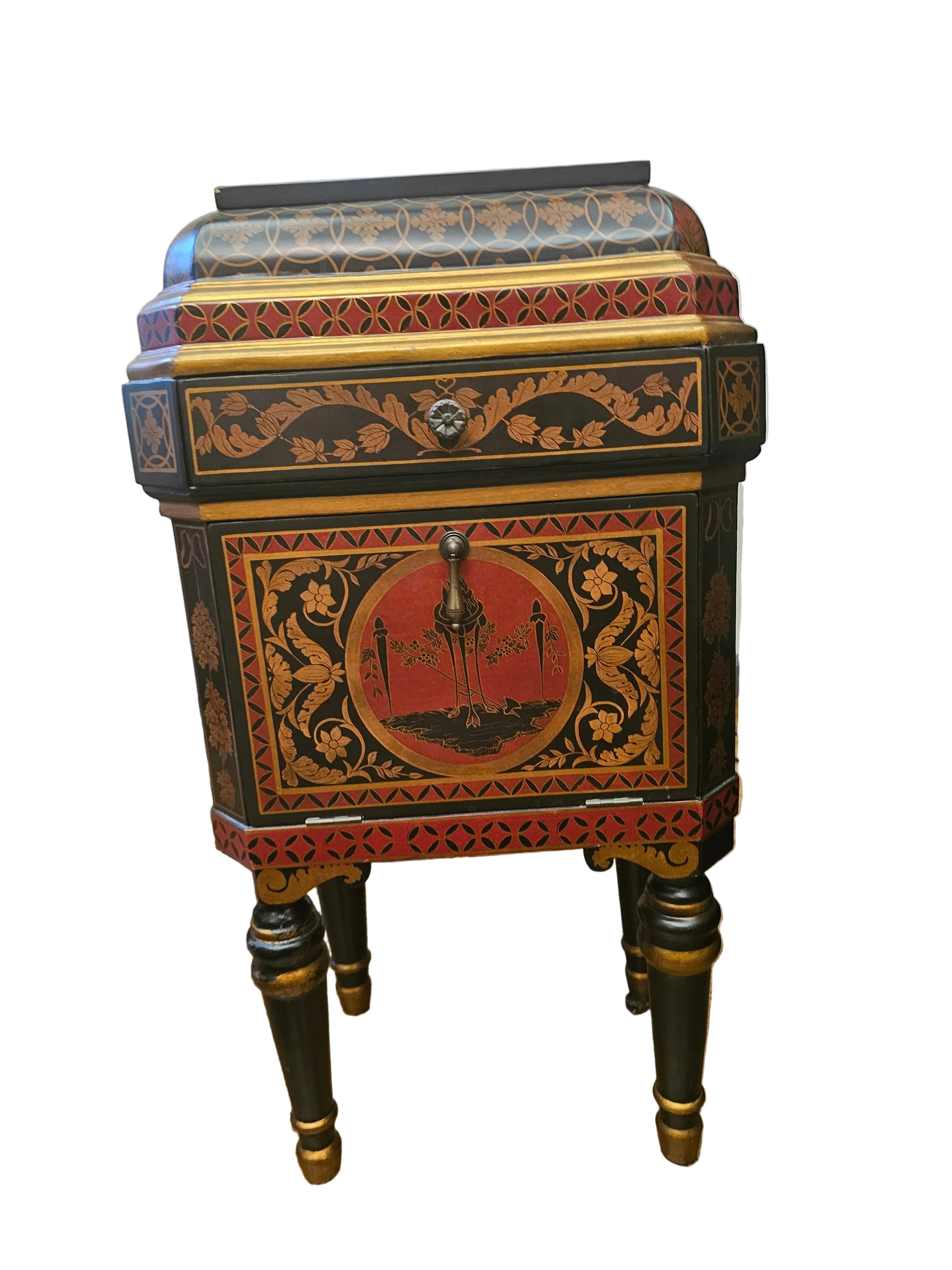 A vintage decorative nightstand with intricate floral patterns, featuring a red and black color scheme, and ornate gold detailing, stands on four legs.