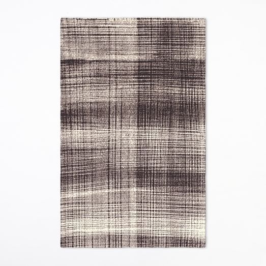 Textured area rug with a plaid pattern on a white background