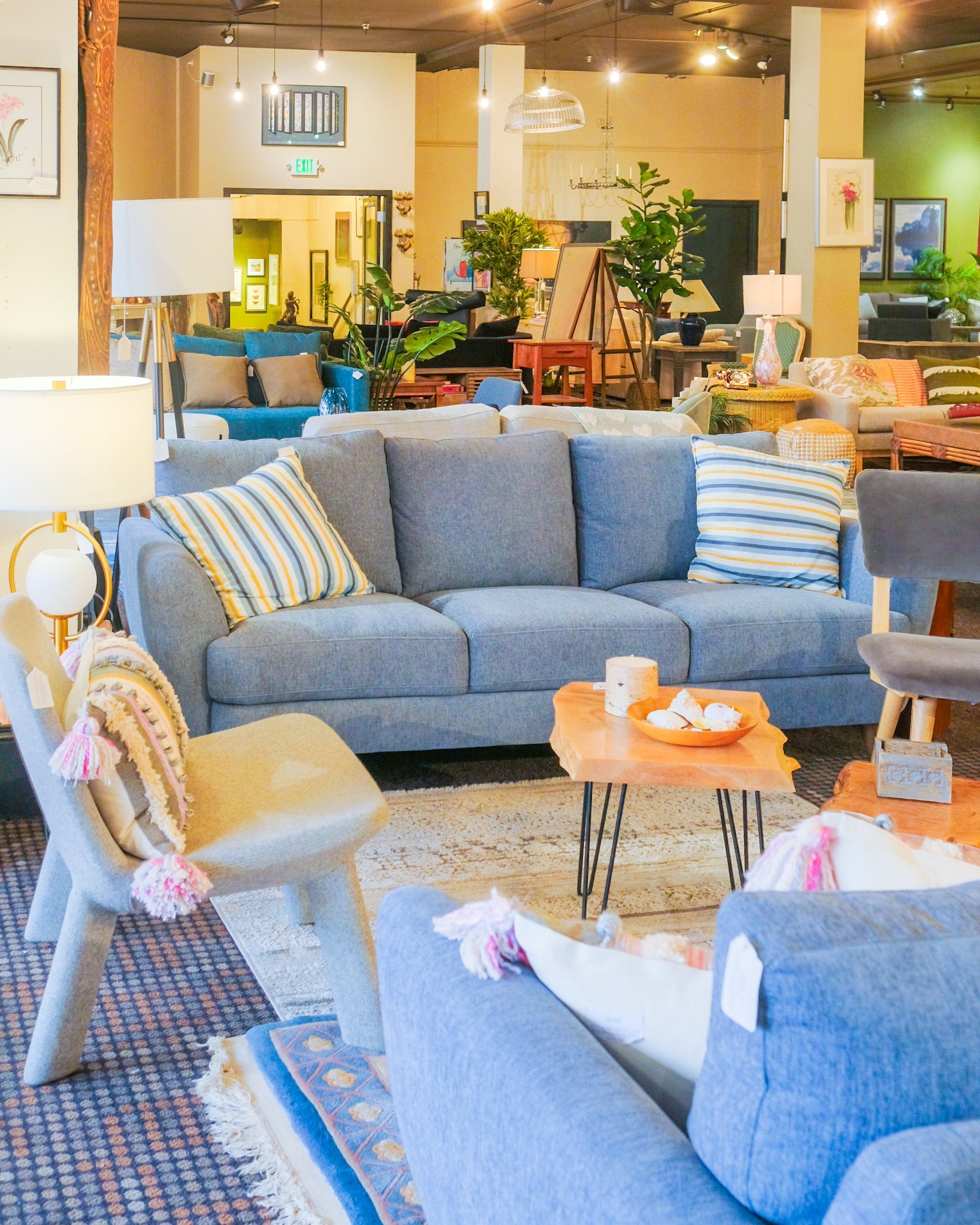 Living room with blue sofa, colorful pillows, and decorative items.
