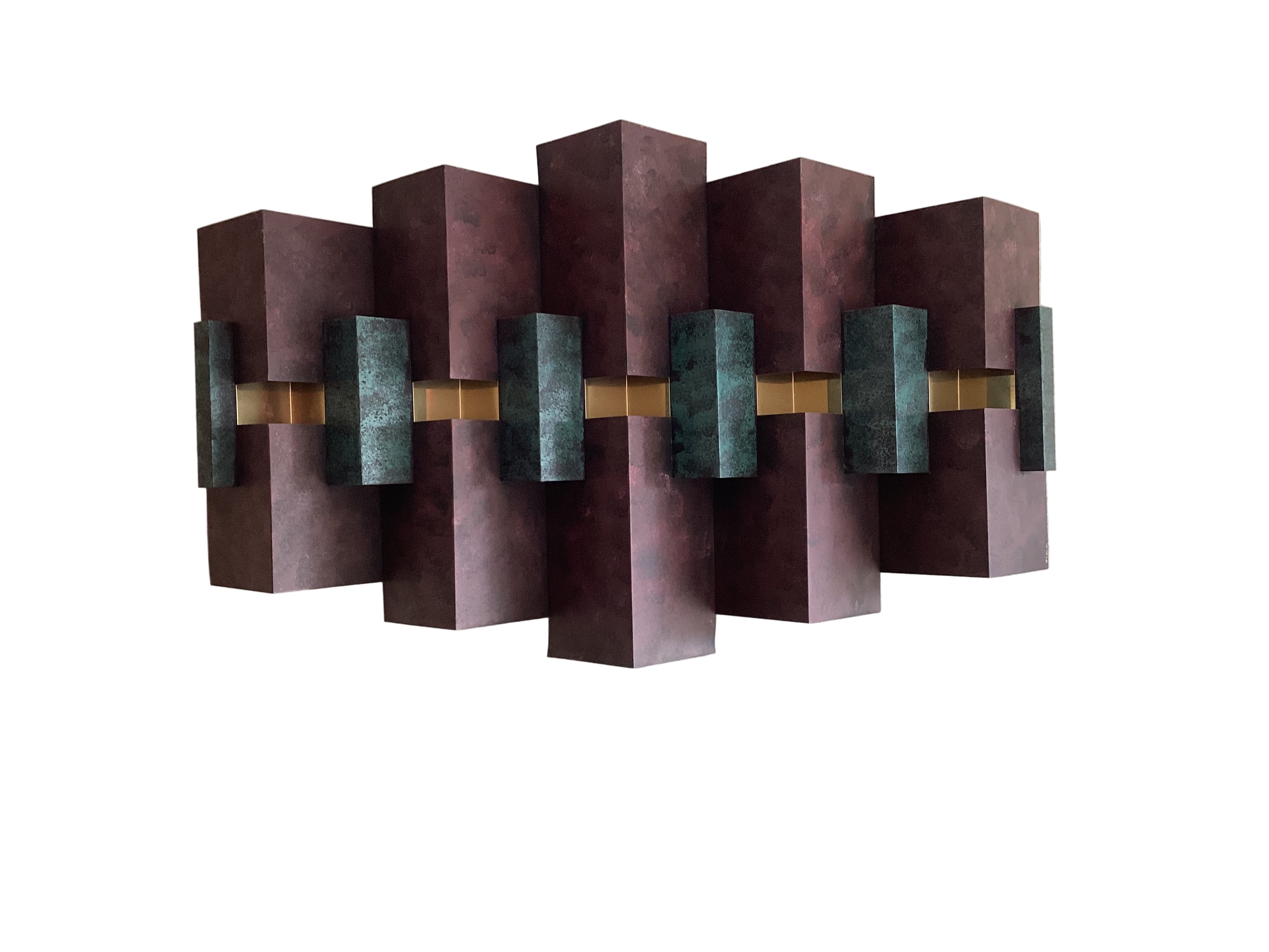 Abstract wall art features a series of vertical, rectangular panels in dark maroon and teal with a central gold accent, mounted on a light wall.