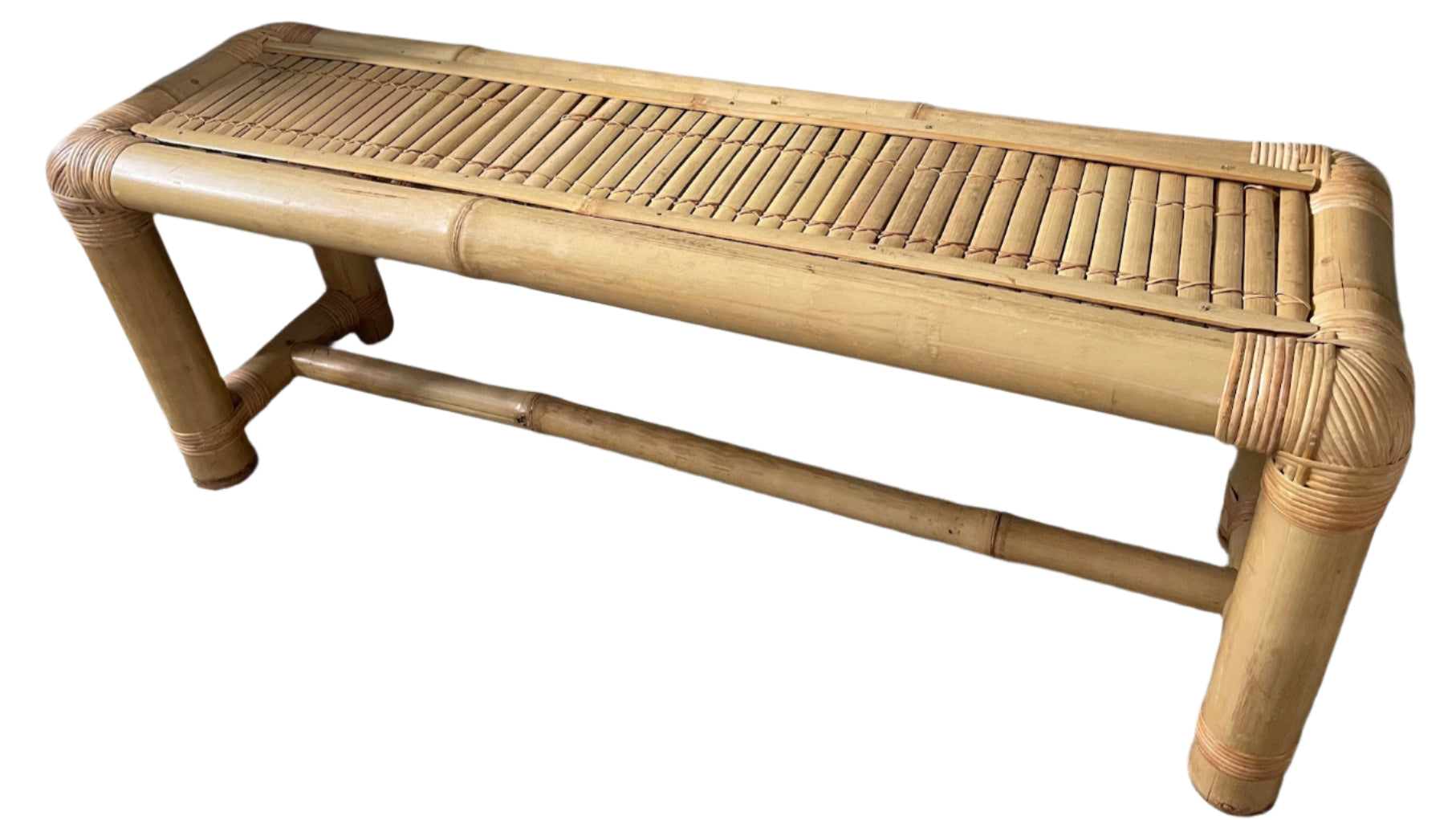 A simple bamboo bench with a slatted top, placed against a green wall. It features rounded corners and sturdy legs on a carpeted floor.