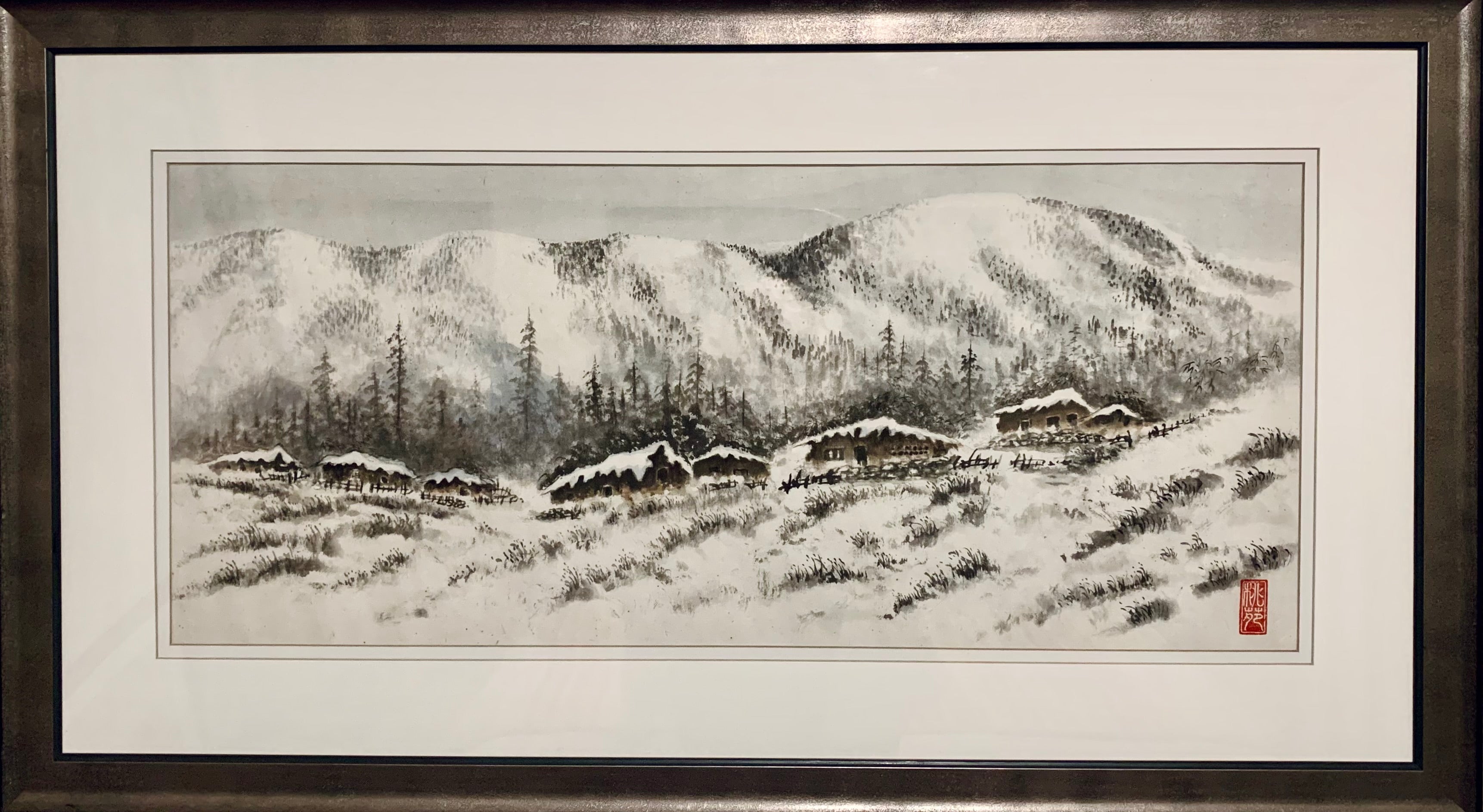 A serene winter landscape featuring snow-covered mountains, pine trees, and rustic cabins nestled in a snowy field, framed elegantly.