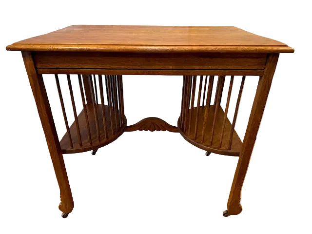 A vintage wooden table with a smooth surface and two curved shelves below, featuring vertical slats on the sides and resting on four rolled legs.